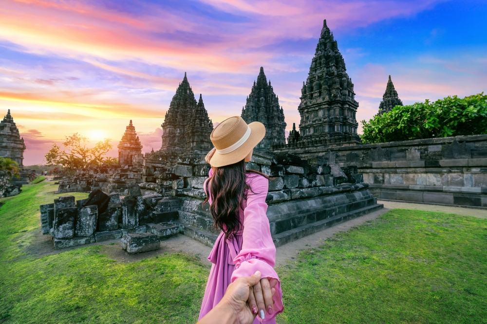 Women,Tourists,Holding,Man's,Hand,And,Leading,Him,To,Prambanan