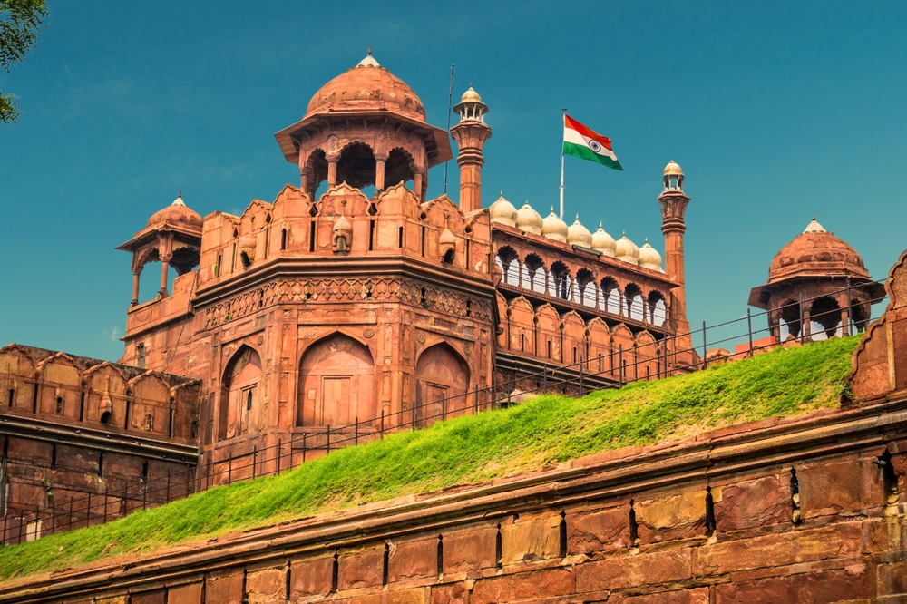 Red,Fort,Delhi,India,With,India,Flag,Flying,High.